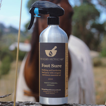 Bottle of 'Foot Sure' spray with a horse in the background