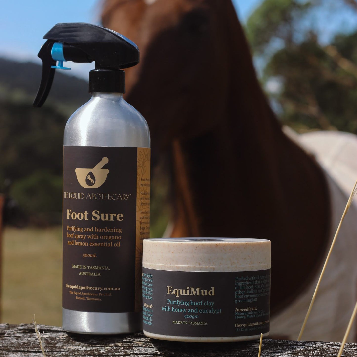 Two horse care products, 'Foot Sure' spray and 'EquiMud' cream, with a horse in the background.